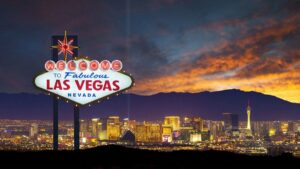 close up of welcome to fabulous las vegas, nevada, usa sign with downtown and sunset in background